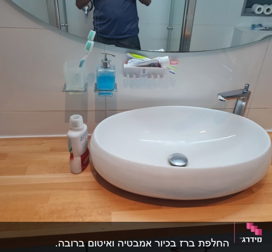 כיור עגול עם ברז כרום על משטח עץ
